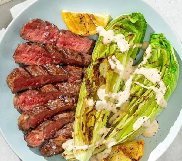 Grilled ribeye steak with grilled caesar salad