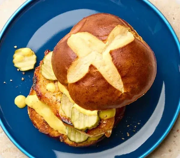 Honey mustard chicken pretzel sandwich on a plate