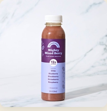 A bottle of Mighty Mixed Berry beverage on marble