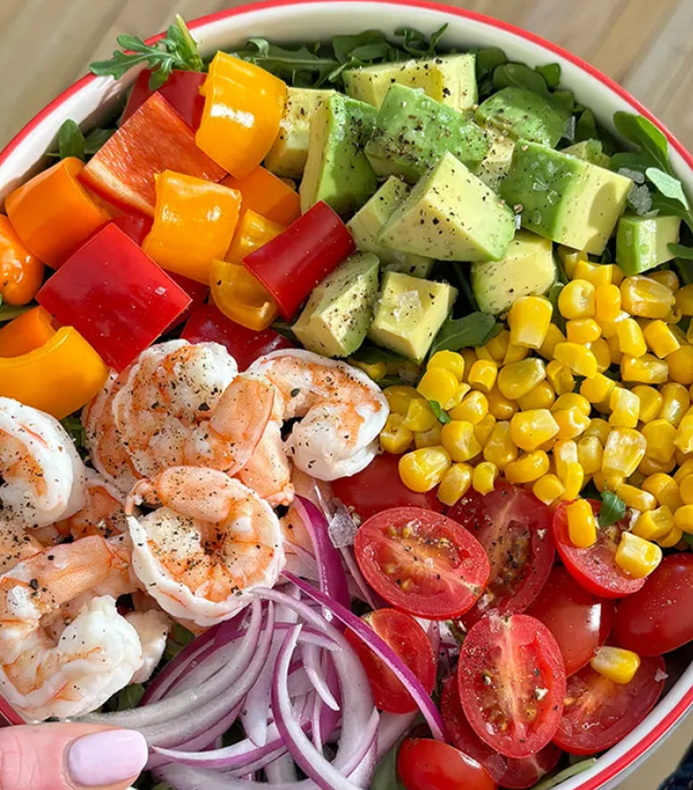 Colorful bowl of salad with shrimp, veggies and avocado